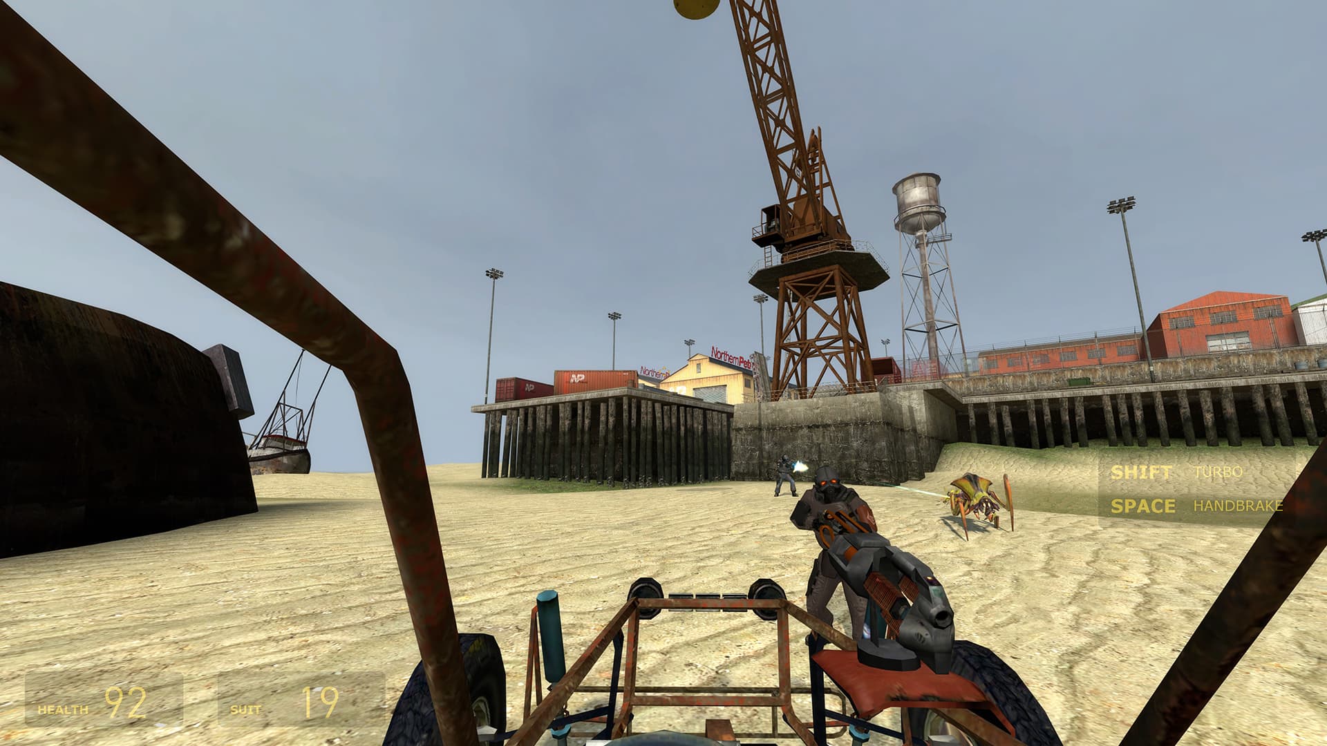 A screenshot from Half-Life 2. Near the pier on the coastline, a Combine soldier shoots an antlion while another stares at the player driving towards him.