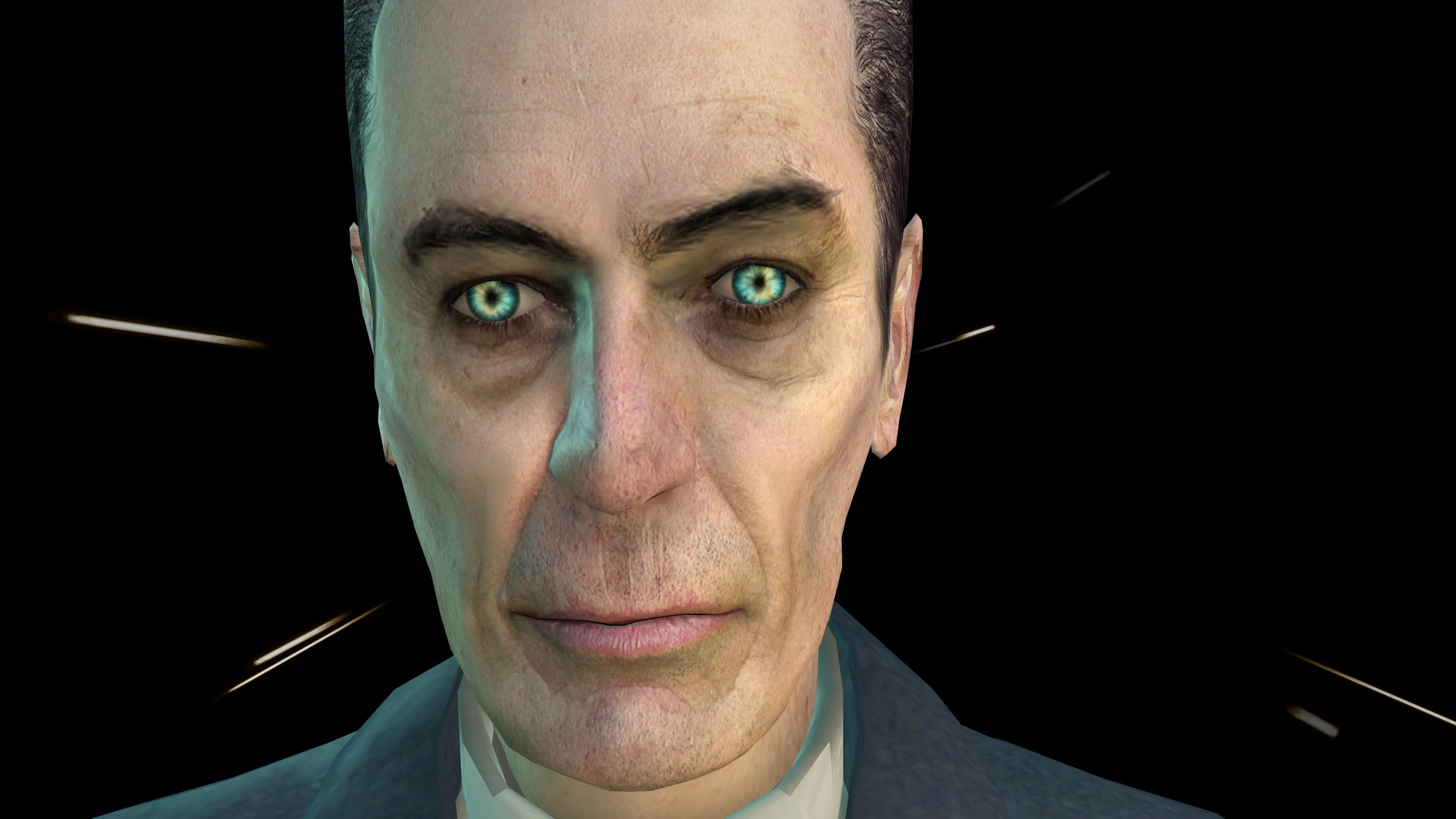 A screenshot from Half-Life 2. A photorealistic man with bright blue and green eyes and a gaunt face wearing a blue suit, the G-Man, stares at the camera in a dark void.