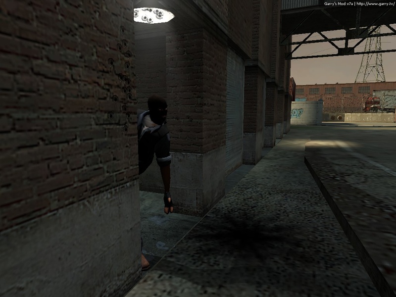 Yet another terrorist peeks out from a building at scorch marks from grenades on the floor.